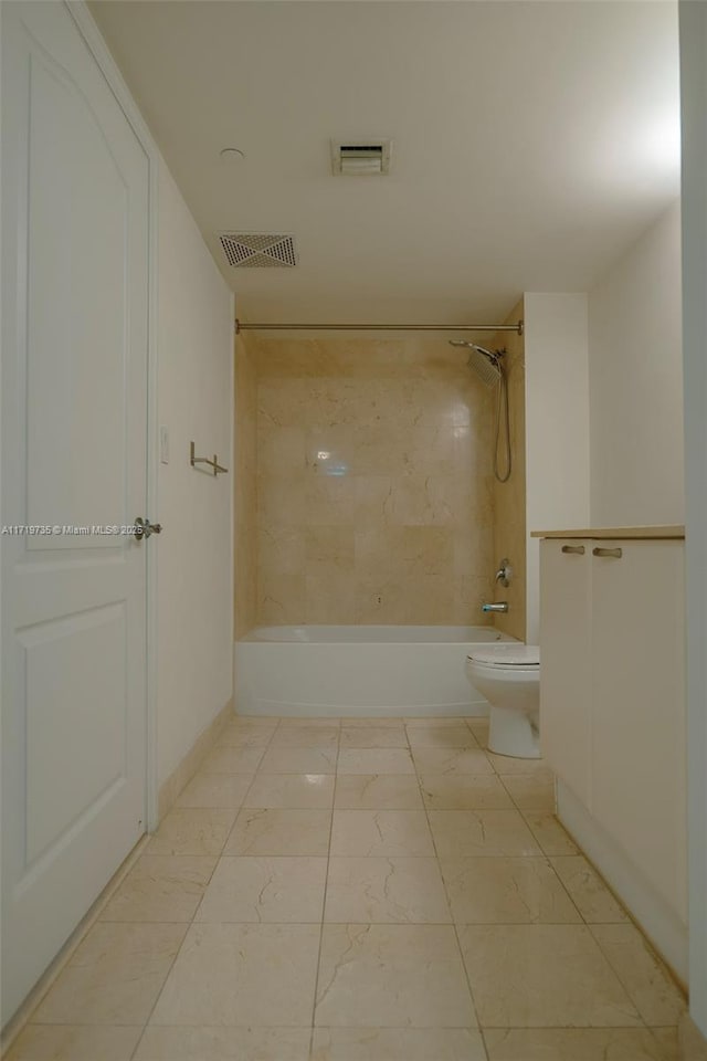 bathroom featuring tiled shower / bath combo and toilet