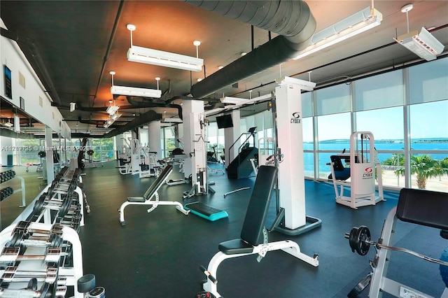 gym with a wall mounted AC and a wall of windows