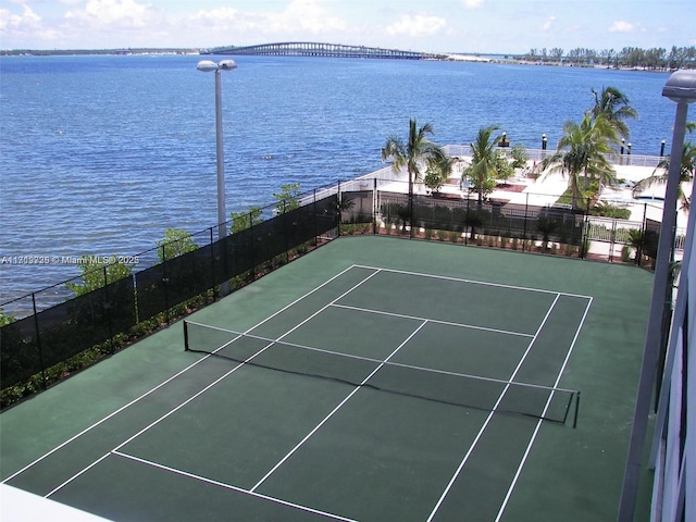 view of tennis court featuring a water view