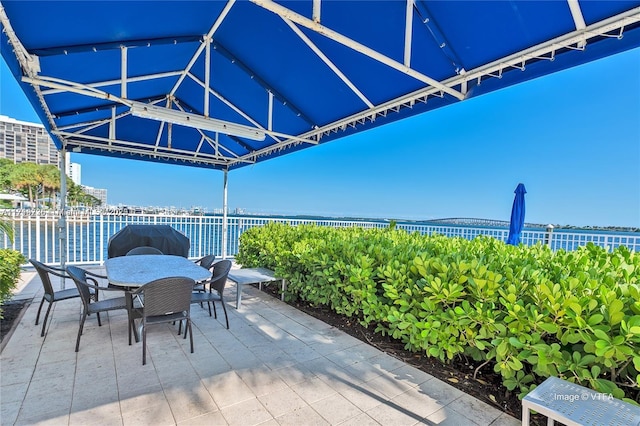 view of patio / terrace with grilling area and a water view