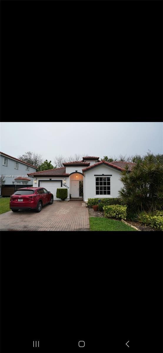 16817SW 90th St, Miami, FL 33196 - view of front of home with an attached garage and stucco siding