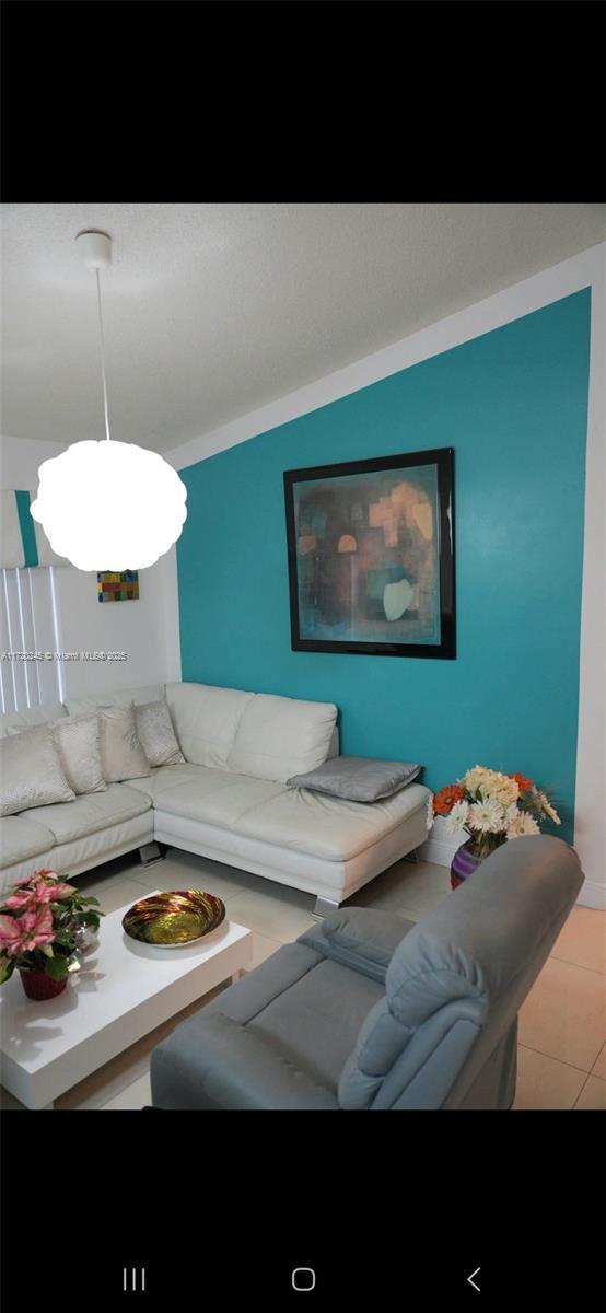 living room with light tile patterned flooring and lofted ceiling