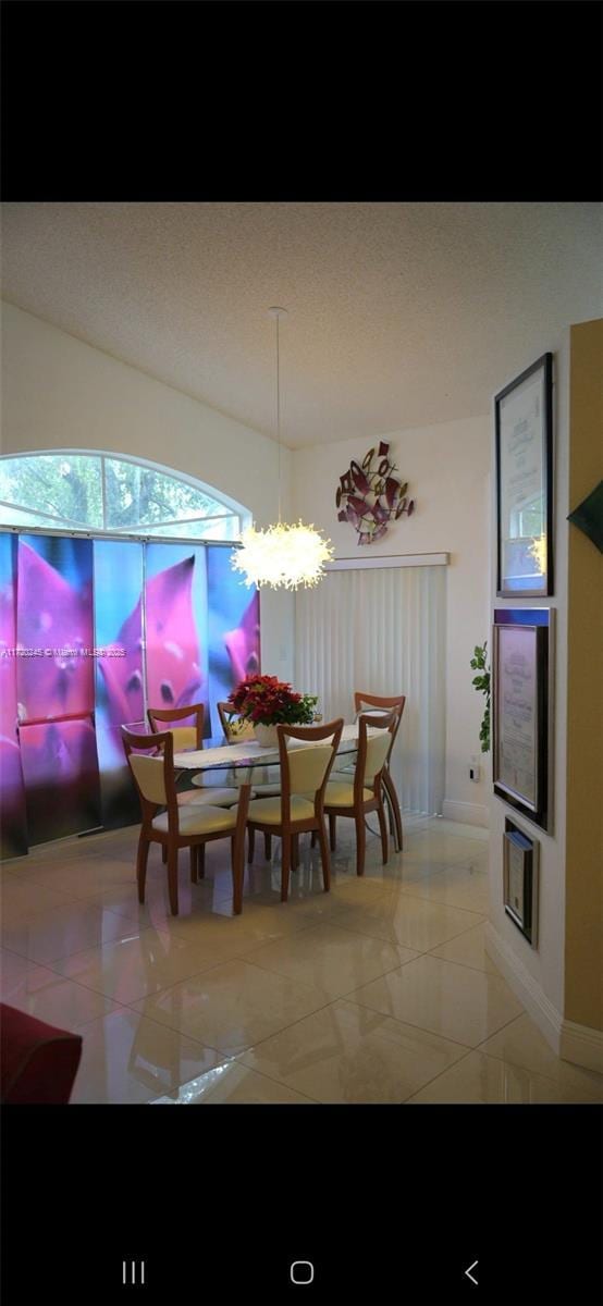 tiled dining area featuring a chandelier