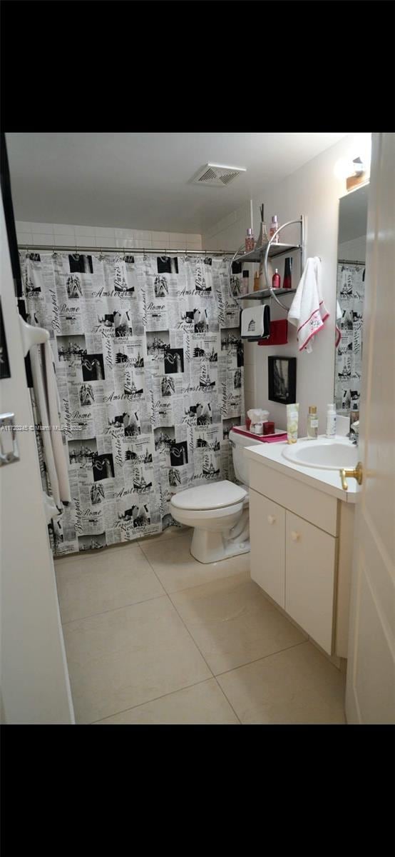 bathroom featuring tile patterned flooring, vanity, and toilet