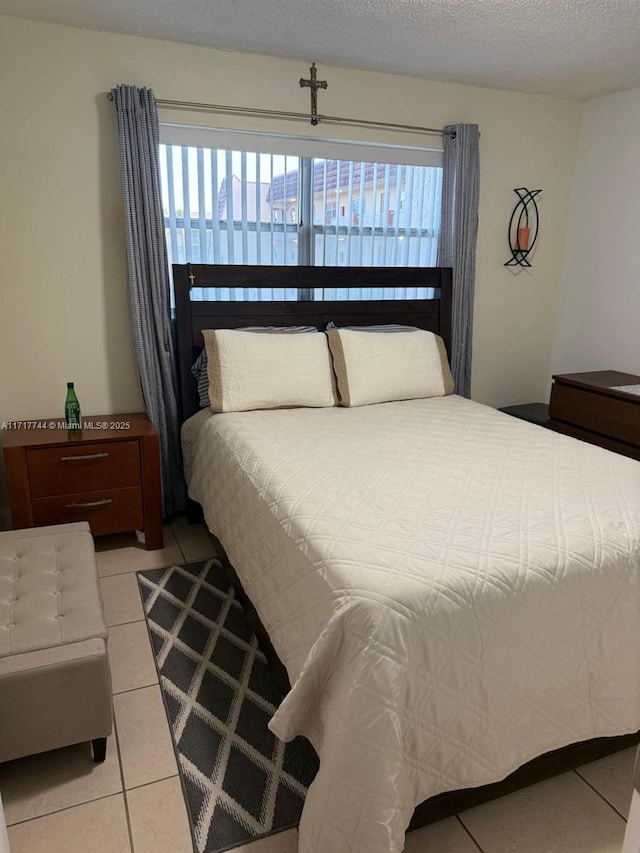 tiled bedroom with multiple windows and a textured ceiling