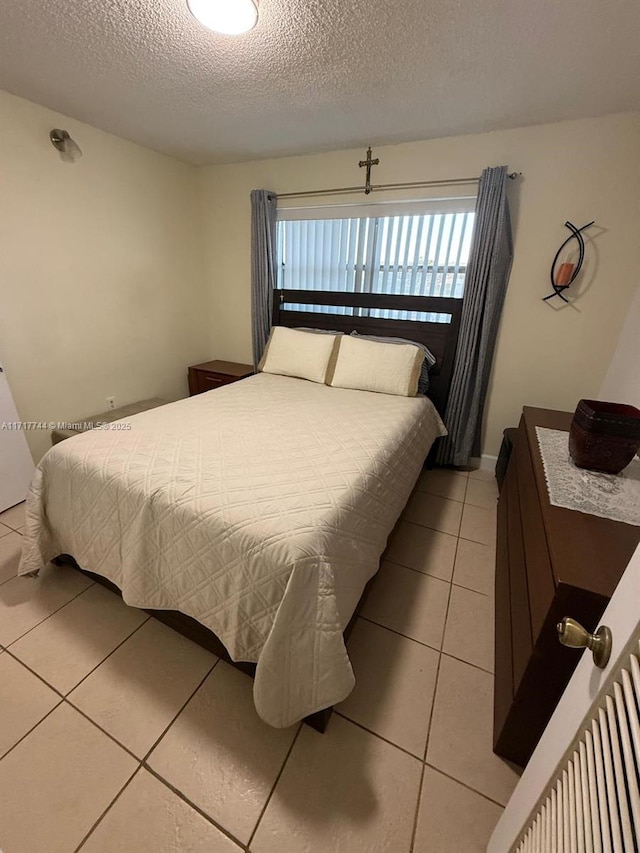 bedroom featuring tile patterned floors and a textured ceiling