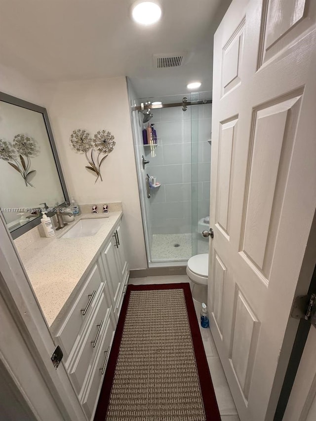 bathroom with vanity, toilet, and a shower with shower door