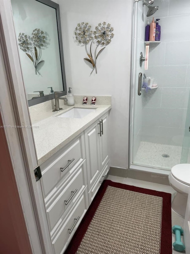 bathroom with toilet, a shower with door, vanity, and tile patterned flooring