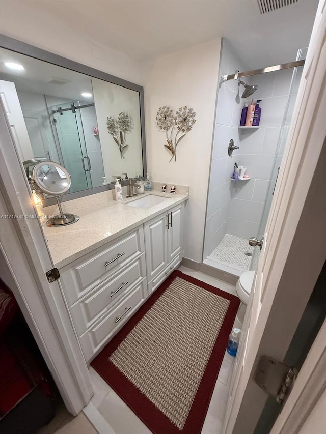 bathroom featuring vanity, toilet, and a shower with shower door