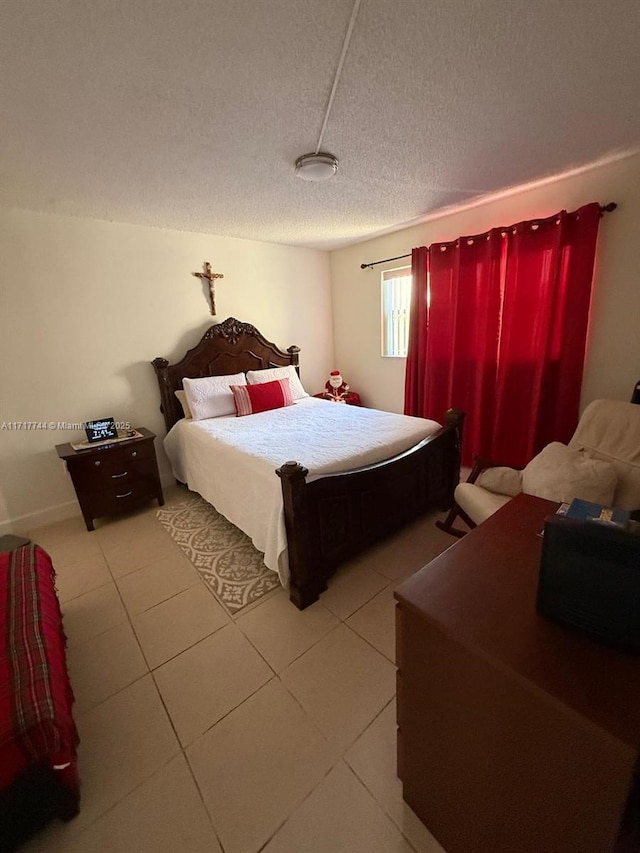 bedroom featuring light tile patterned floors and a textured ceiling