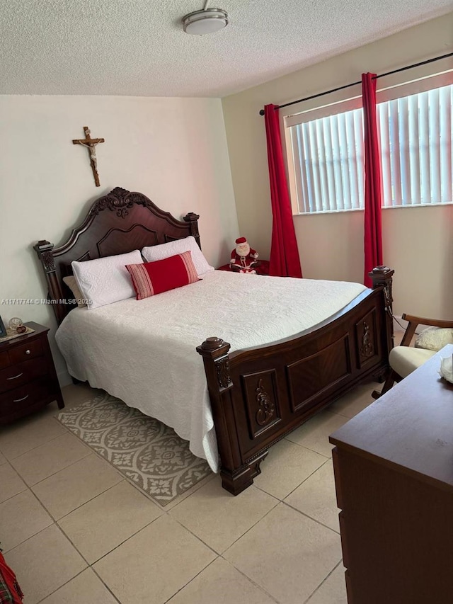 bedroom with light tile patterned floors and a textured ceiling