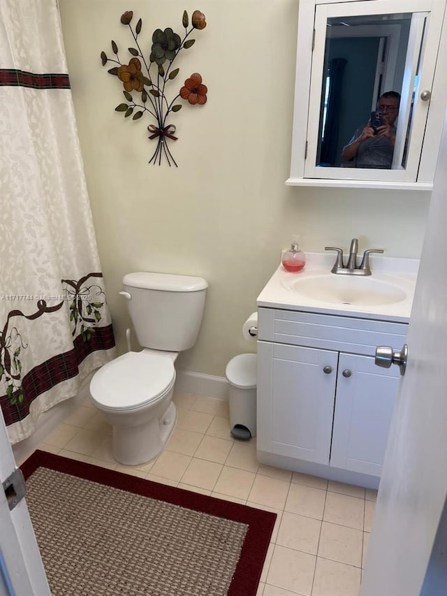 bathroom featuring curtained shower, tile patterned flooring, vanity, and toilet