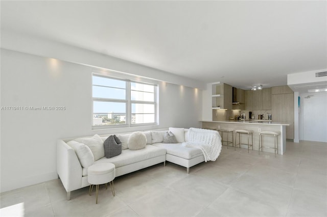 living room featuring light tile patterned floors and visible vents