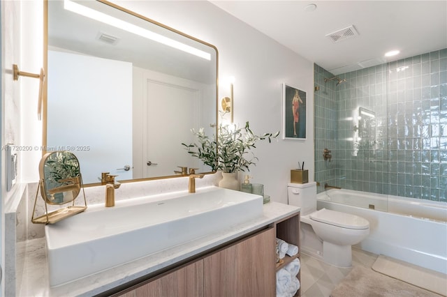 full bathroom featuring tiled shower / bath combo, toilet, and vanity