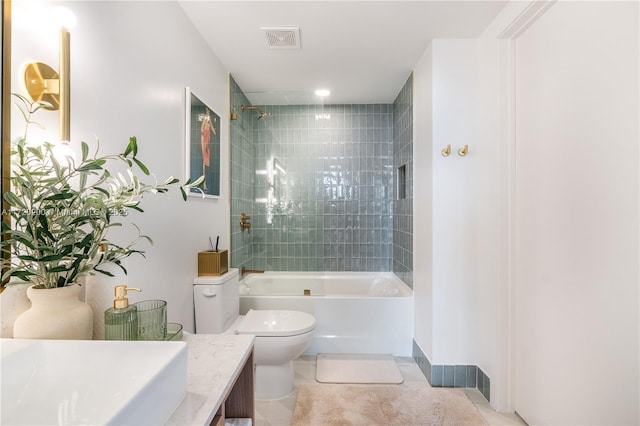 full bathroom featuring tile patterned flooring, vanity, toilet, and tiled shower / bath