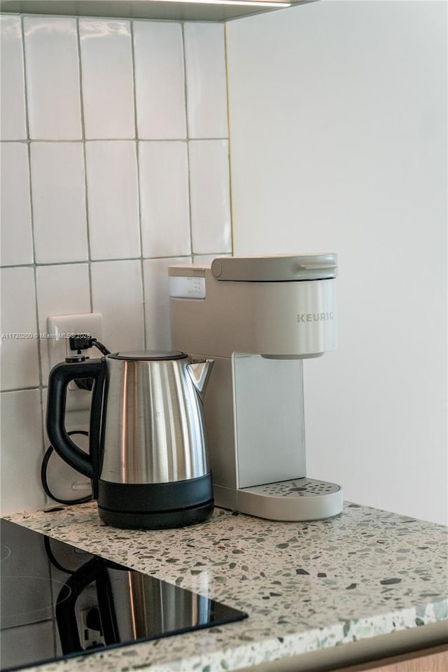 details featuring white cabinets, decorative backsplash, and light stone countertops