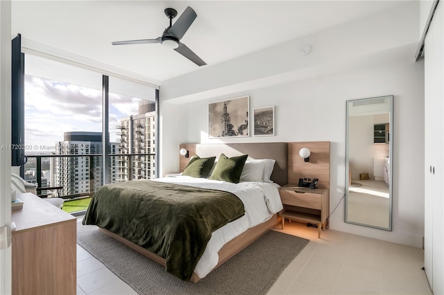 bedroom featuring access to exterior, multiple windows, ceiling fan, and a wall of windows