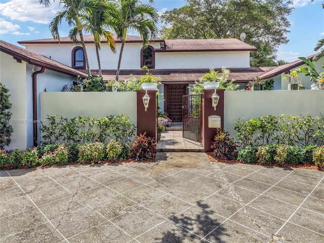 1524 39th St, West Palm Beach, FL 33407 - view of front of property featuring stucco siding, a gate, and a fenced front yard