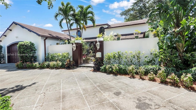 1524 39th St, West Palm Beach, FL 33407 - view of front of home with stucco siding, a gate, an attached garage, and driveway