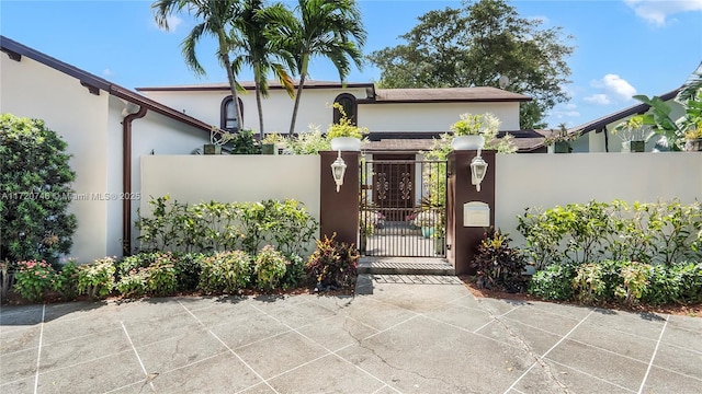 1524 39th St, West Palm Beach, FL 33407 - view of front of house featuring a gate, stucco siding, and a fenced front yard