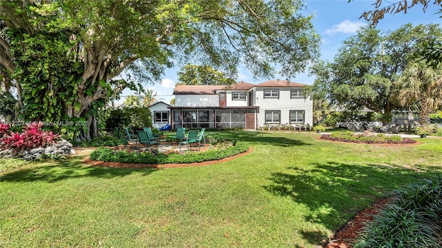 1524 39th St, West Palm Beach, FL 33407 - back of property featuring a sunroom, a lawn, and stucco siding