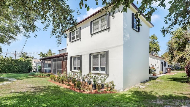 1524 39th St, West Palm Beach, FL 33407 - view of side of property featuring a sunroom, a lawn, and stucco siding