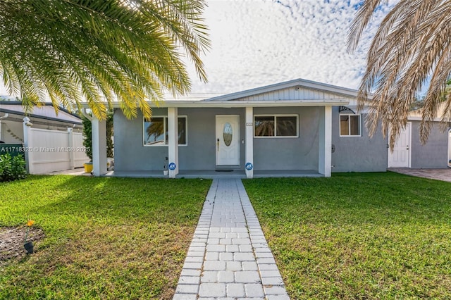 view of front of property featuring a front yard, a porch, and stucco siding