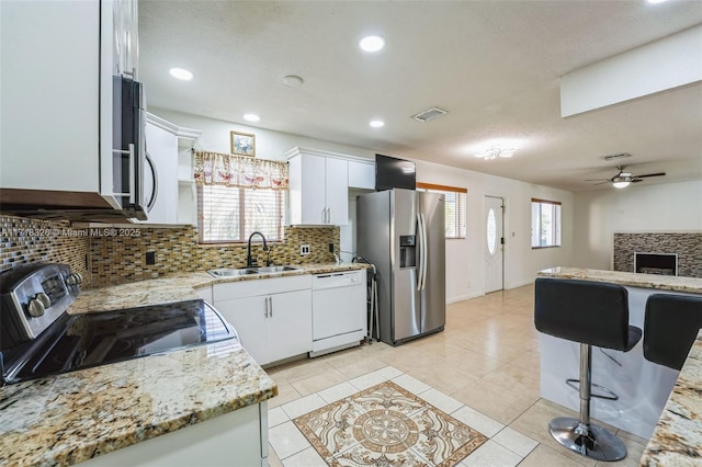 kitchen with light tile patterned floors, visible vents, white cabinets, appliances with stainless steel finishes, and a sink