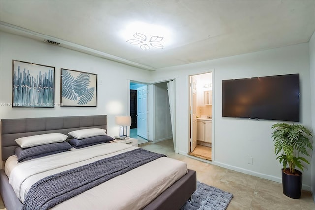 bedroom with visible vents, baseboards, and ensuite bathroom