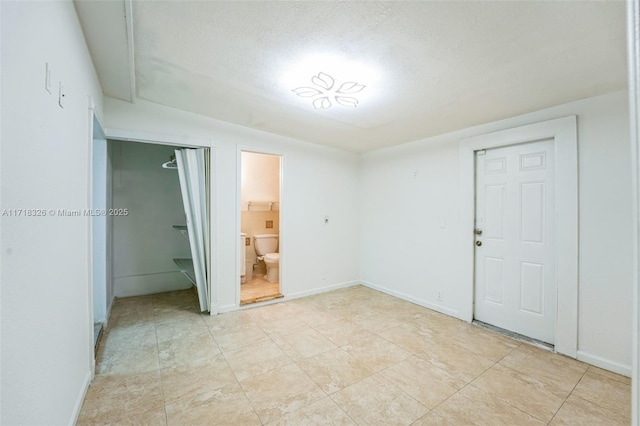 empty room with baseboards and a textured ceiling