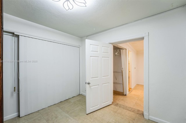 unfurnished bedroom with a closet and a textured ceiling