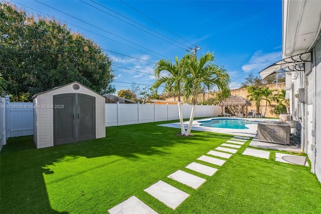 view of yard featuring a fenced in pool, a shed, cooling unit, a fenced backyard, and an outdoor structure