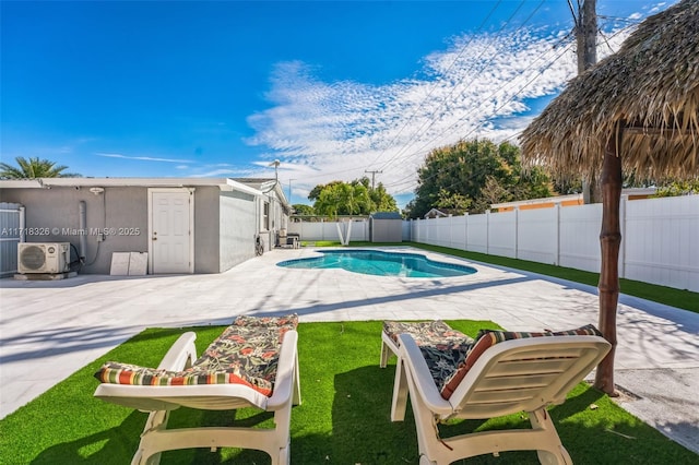 view of swimming pool with a fenced backyard, a yard, a fenced in pool, ac unit, and a patio area