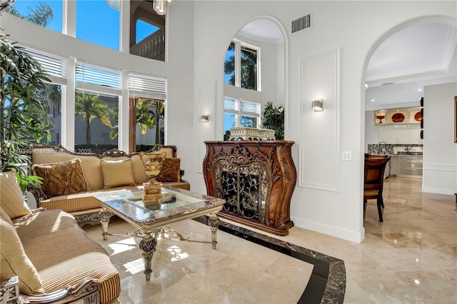 living area with ornamental molding and a high end fireplace