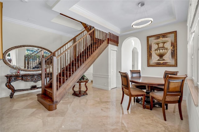 dining room with a tray ceiling, a chandelier, and ornamental molding