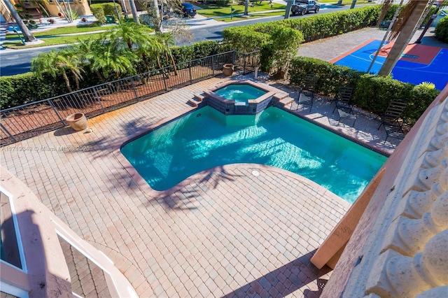 view of swimming pool featuring an in ground hot tub and a patio