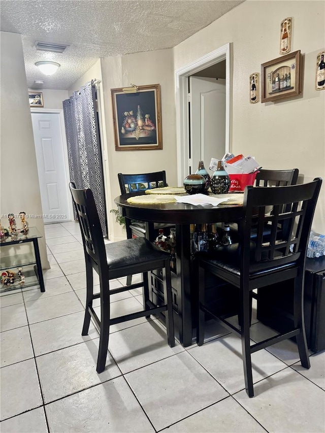 tiled dining area with a textured ceiling