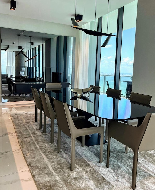 dining space featuring floor to ceiling windows and a water view