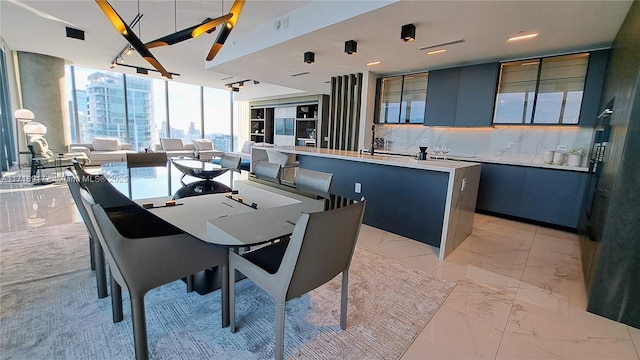 dining area featuring floor to ceiling windows and sink