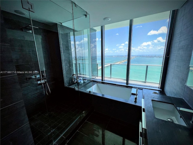 bathroom featuring separate shower and tub, tile patterned flooring, and a water view