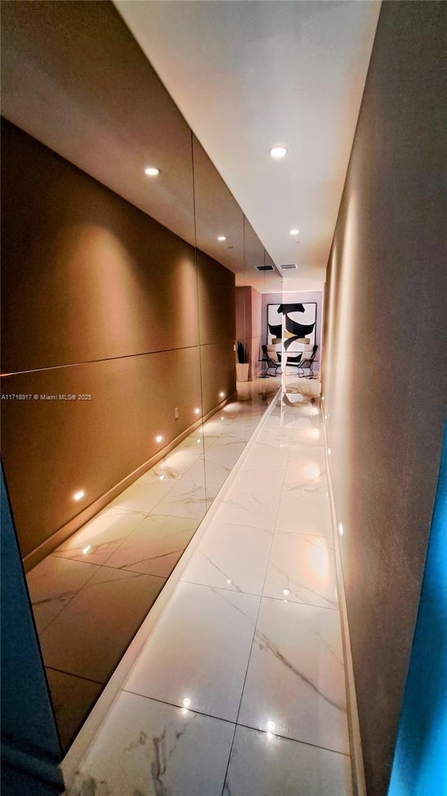 hall featuring visible vents, recessed lighting, and marble finish floor