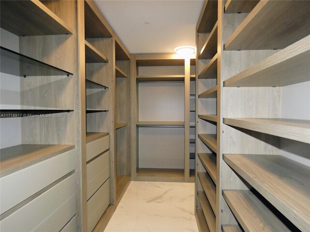 spacious closet with marble finish floor