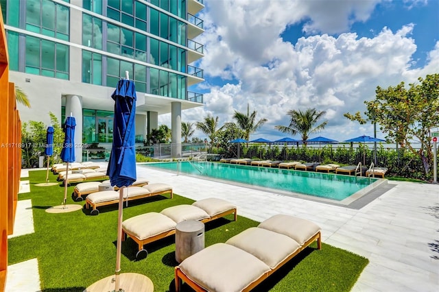 view of swimming pool featuring a patio and a lawn