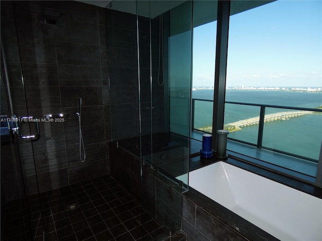 full bath with a water view, a shower stall, and a garden tub