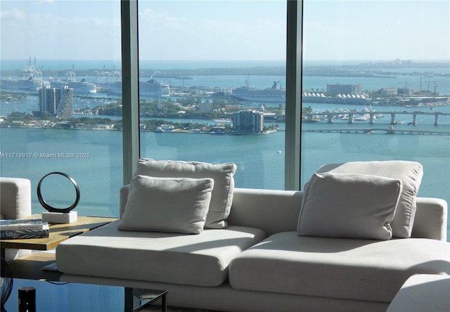 interior space featuring outdoor lounge area, a city view, and a water view