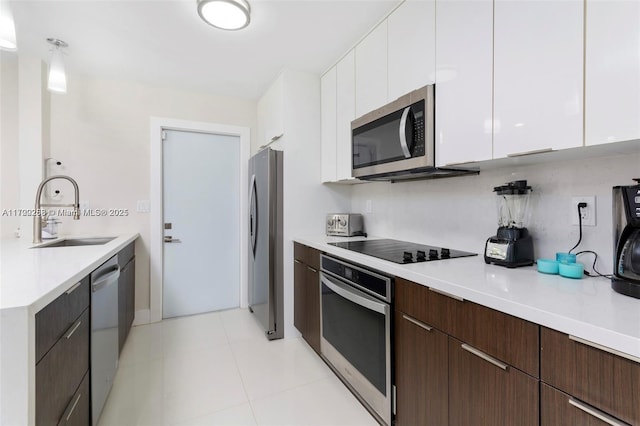 kitchen with dark brown cabinets, white cabinetry, sink, and appliances with stainless steel finishes