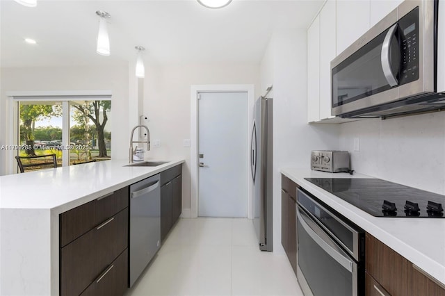 kitchen featuring pendant lighting, white cabinets, sink, dark brown cabinets, and stainless steel appliances