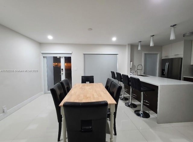 dining area featuring french doors, sink, and light tile patterned flooring