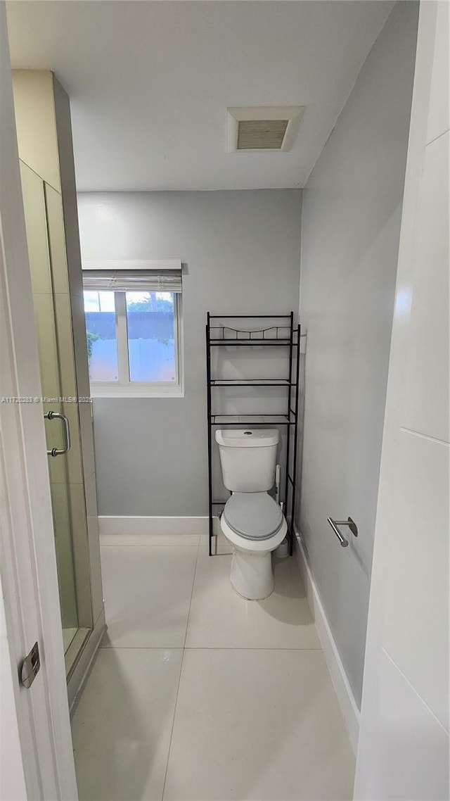 bathroom with toilet, tile patterned floors, and walk in shower