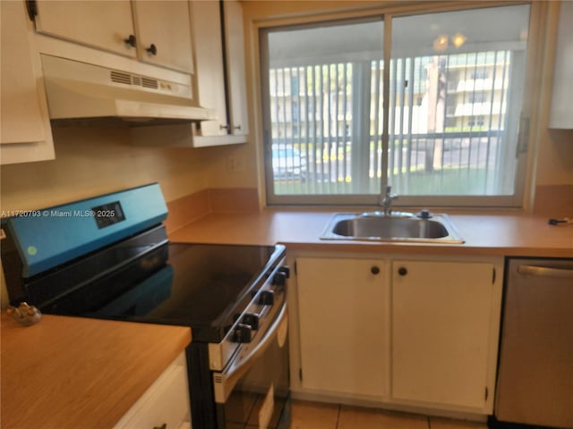 kitchen with white cabinetry, stainless steel appliances, sink, and light tile patterned floors